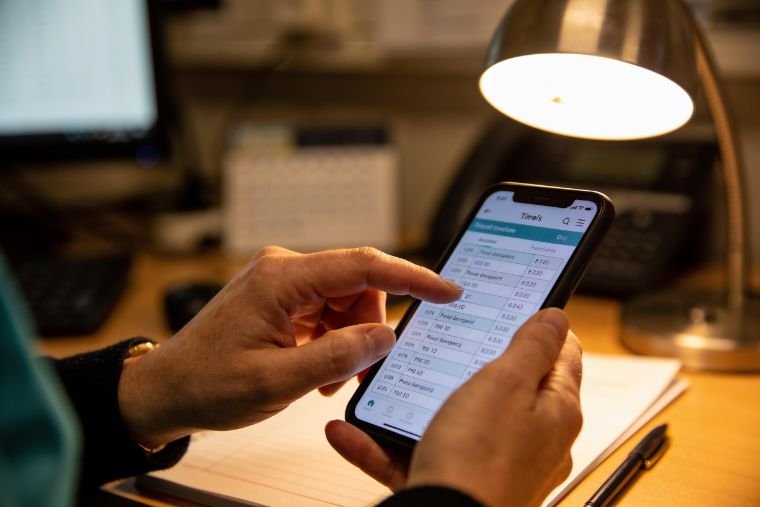 A Bristol care-home manager approving a MAP HealthCare timesheet on a smartphone